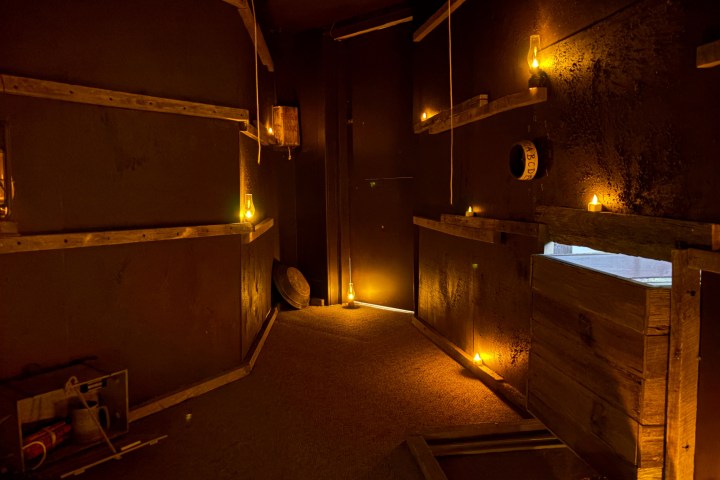 Dimly lit escape room with candles, a mine shaft