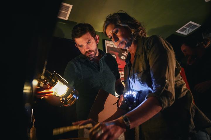 A man and a woman looking at a clue