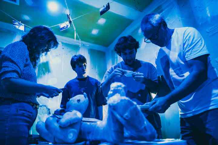 A group of people looking at clues in a dark room