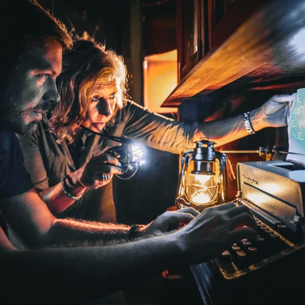 A man and a woman looking at a prop using a lantern
